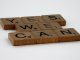 Scrabble tiles spelling 'Yes We Can' on a white background, conveying encouragement.